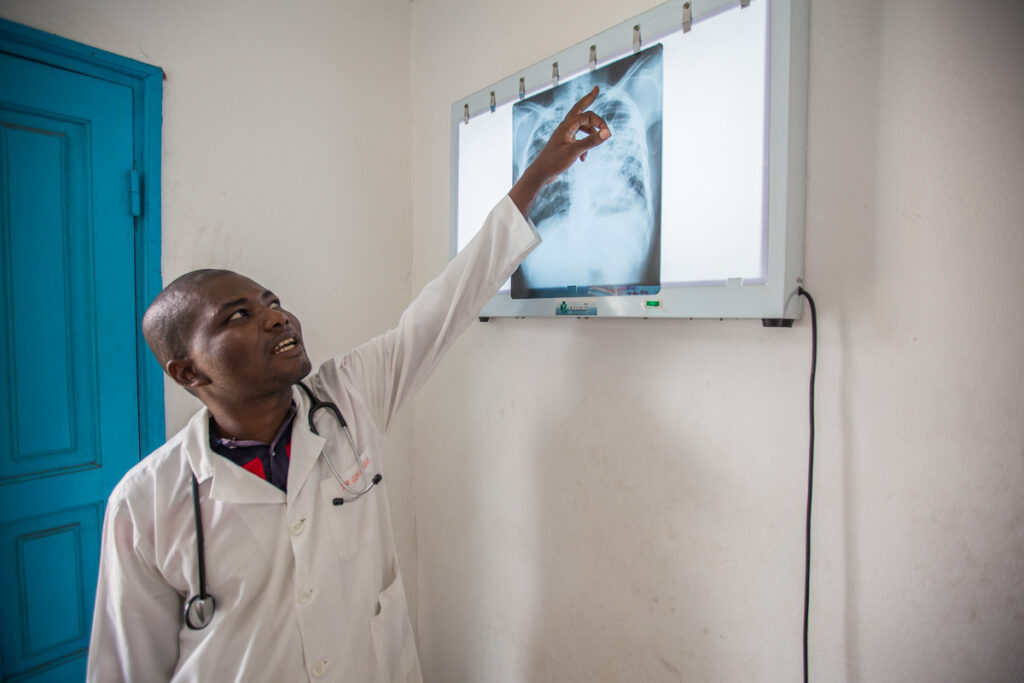 Doctor in Abidjan points up at x-ray