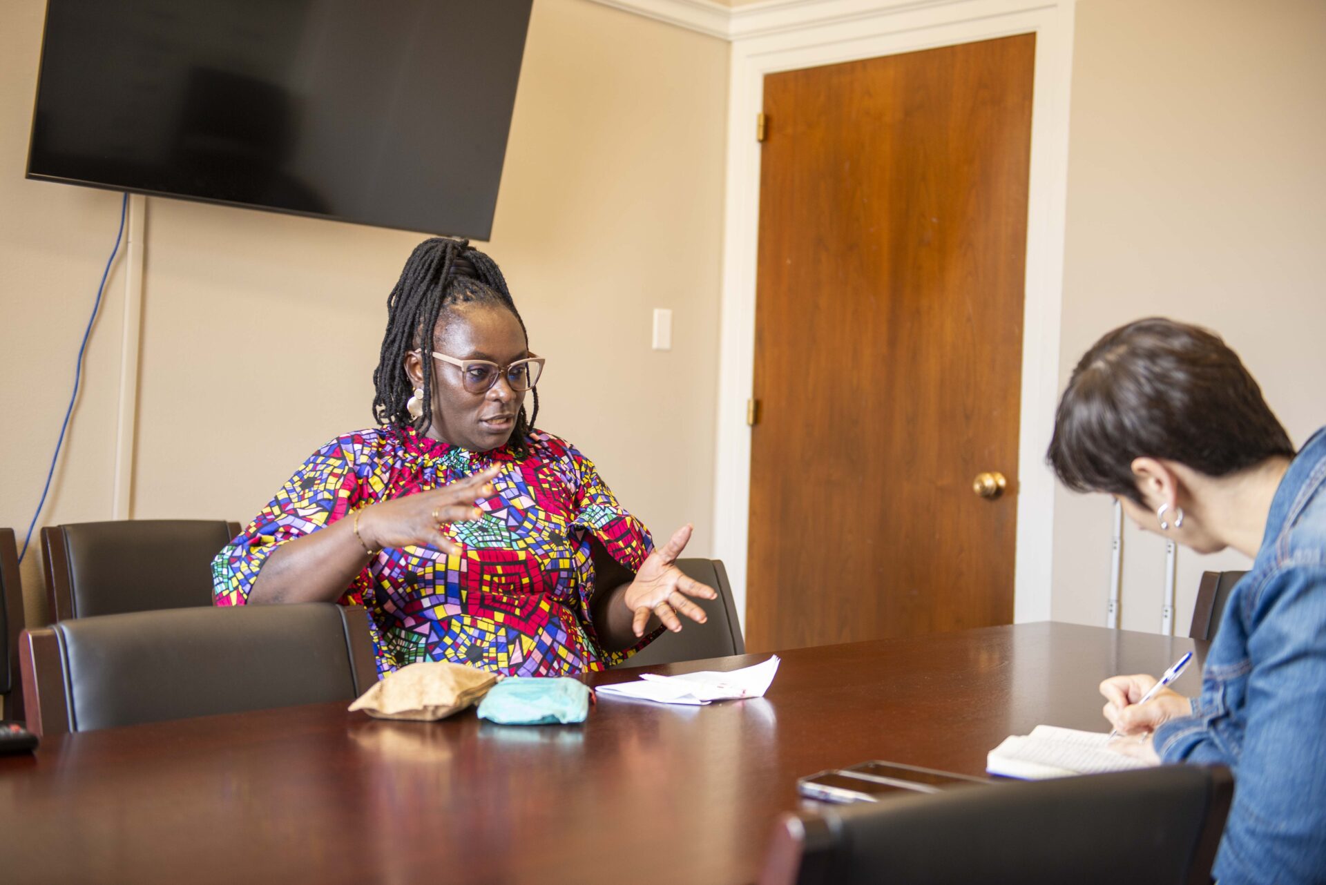 Maurine Murenga explains the impact of the Global Fund to a congressional staffer taking studious notes.